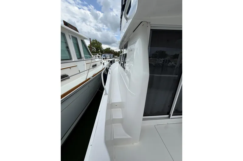 Slide: The Image of 1999 Mainship 350 Trawler side deck view with railing and windows. - 5