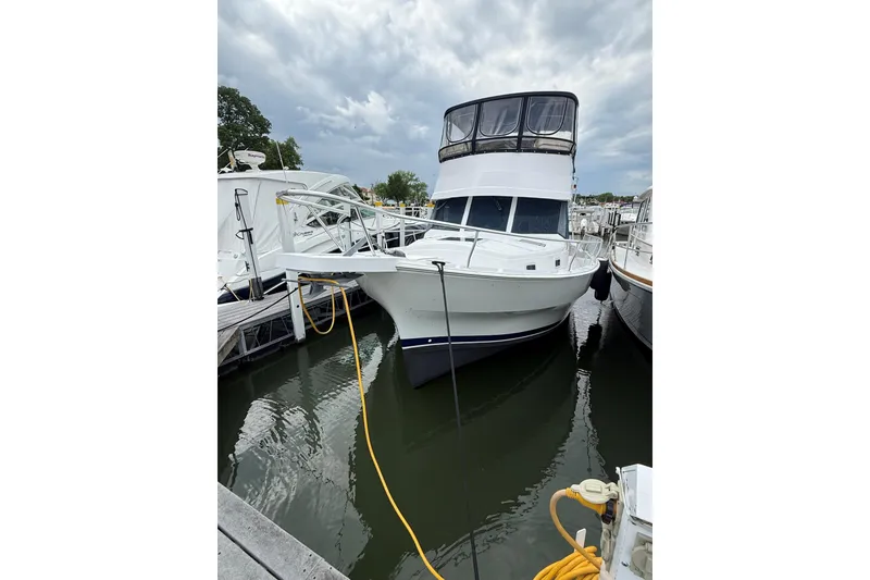Slide: The Image of 1999 Mainship 350 Trawler docked at marina under cloudy sky. - 2