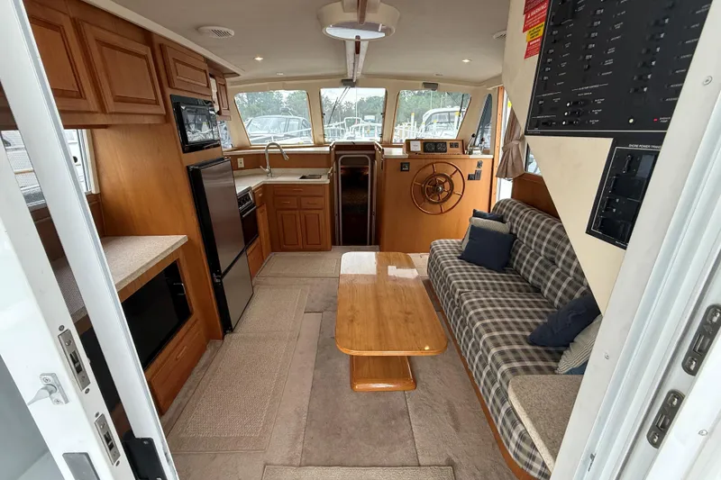Slide: The Image of Interior of 1999 Mainship 350 Trawler with cozy seating, kitchenette, and helm station. - 16