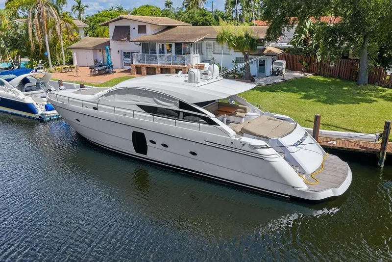 Slide: The Image of 2013 Pershing 64 yacht docked by a waterfront home. - 10