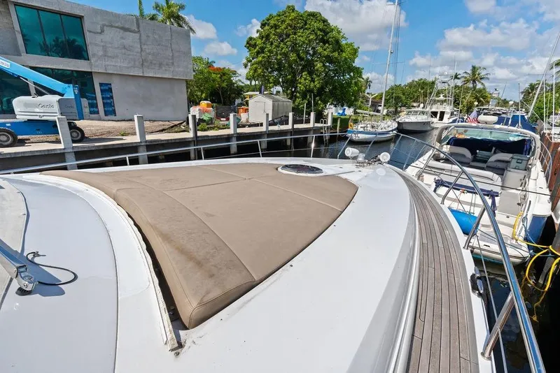 Slide: The Image of 2013 Pershing 64 yacht docked at marina, featuring sleek design and spacious deck. - 13