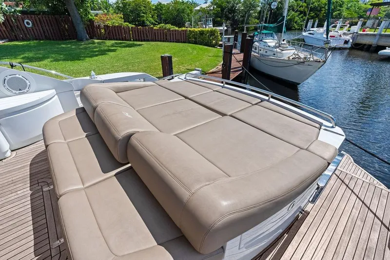 Slide: The Image of Luxurious sunbed on 2013 Pershing 64 yacht docked by a serene waterfront. - 16