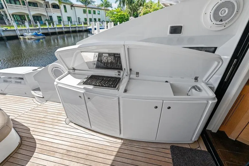 Slide: The Image of Outdoor kitchen on 2013 Pershing 64 yacht with grill and sink, docked by waterfront homes. - 17
