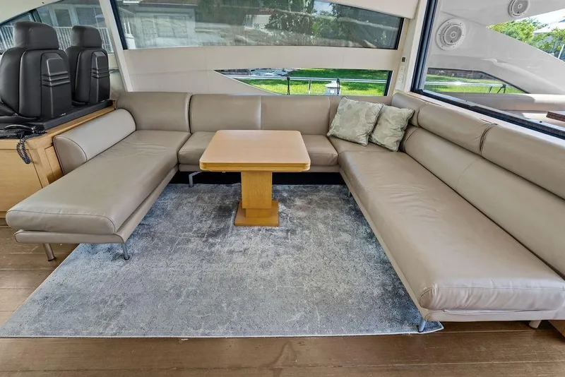 Slide: The Image of Luxurious interior of 2013 Pershing 64 yacht with beige leather seating and wooden table. - 21