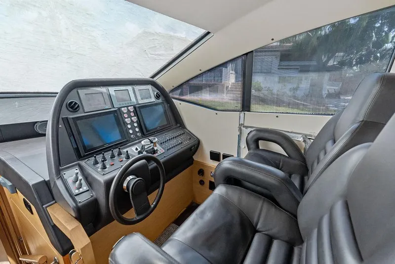 Slide: The Image of Cockpit of 2013 Pershing 64 yacht with advanced navigation controls and leather seating. - 25