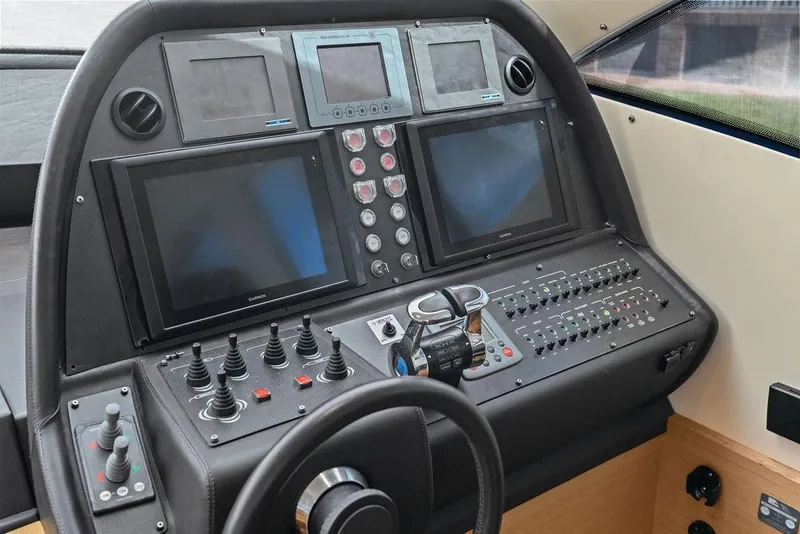 Slide: The Image of Control panel of a 2013 Pershing 64 yacht with multiple screens and controls. - 26