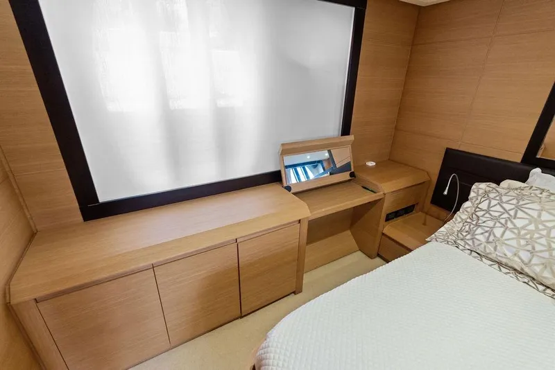 Slide: The Image of Luxurious interior of 2013 Pershing 64 yacht with modern wood furnishings and cozy bedding. - 29