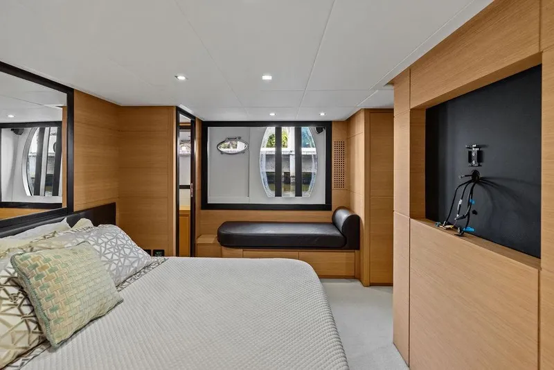 Slide: The Image of Luxurious 2013 Pershing 64 yacht bedroom with modern wood paneling and elegant decor. - 30