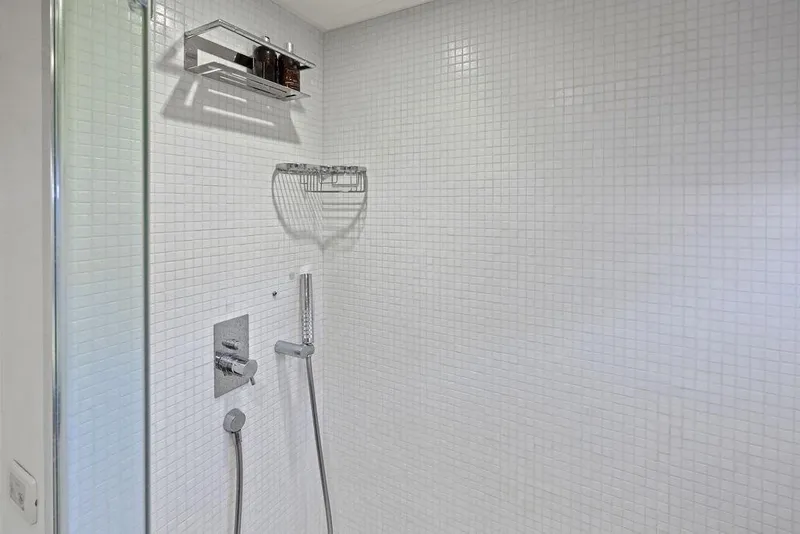 Slide: The Image of Modern shower with white tiled walls and chrome fixtures on a Pershing 64 yacht. - 33