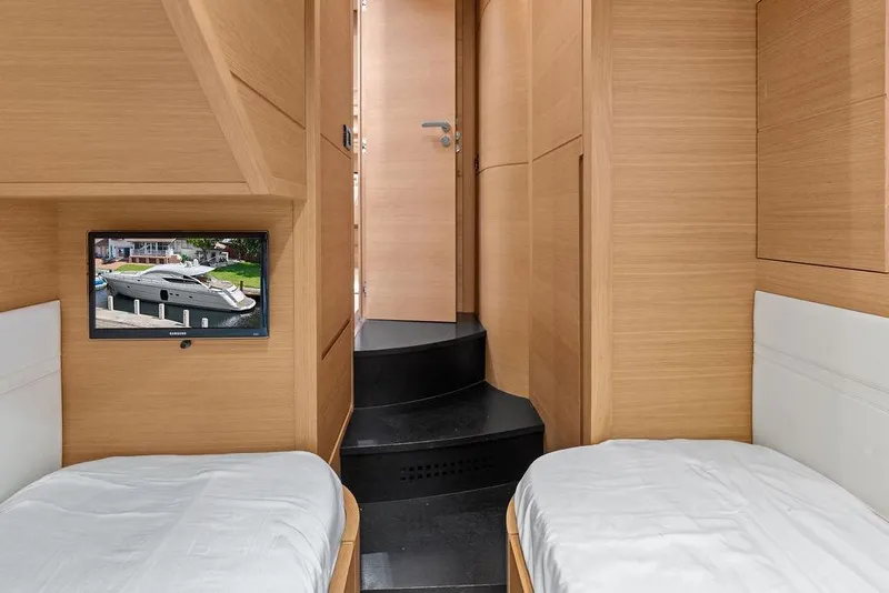 Slide: The Image of Interior of 2013 Pershing 64 yacht with twin beds and wall-mounted TV. - 40