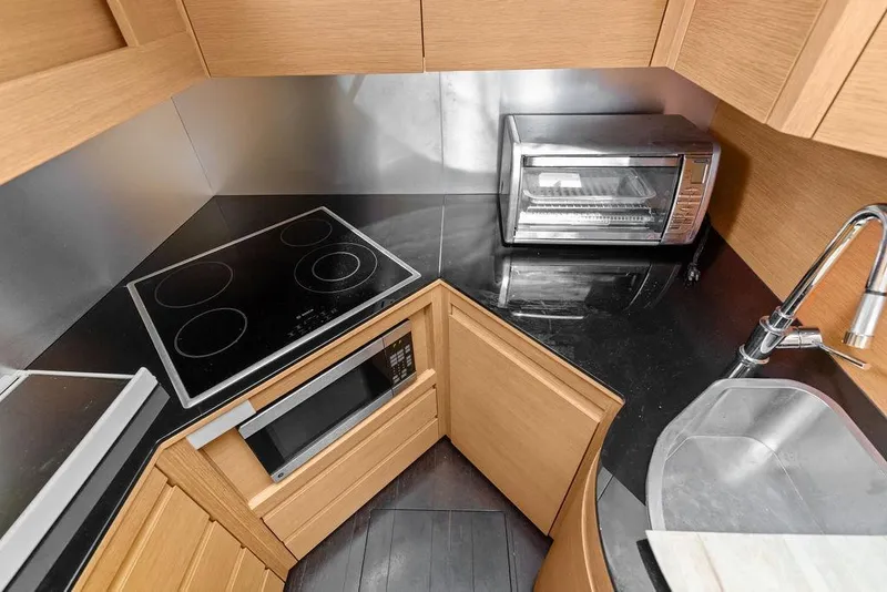 Slide: The Image of Compact kitchen in a 2013 Pershing 64 yacht with stove, oven, and sink. - 44