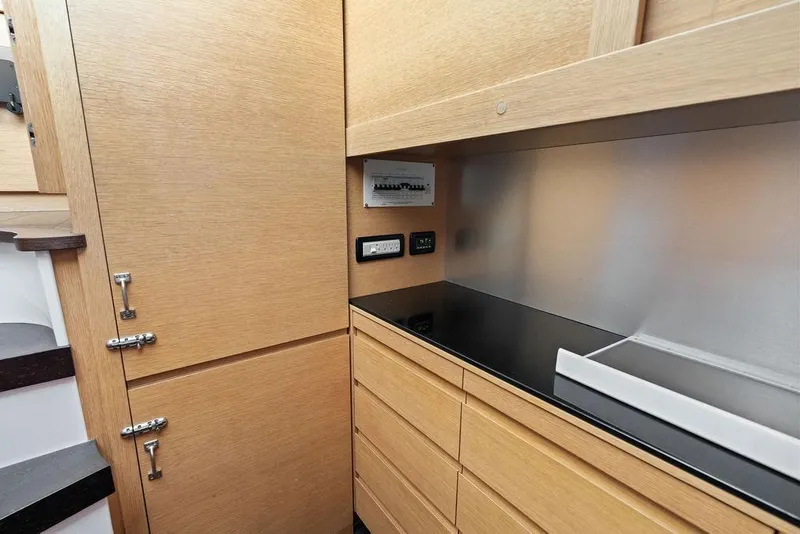 Slide: The Image of Modern kitchen area in a 2013 Pershing 64 yacht with sleek wooden cabinetry. - 45