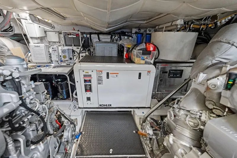 Slide: The Image of Engine room of a 2013 Pershing 64 yacht featuring Kohler generator and mechanical equipment. - 49
