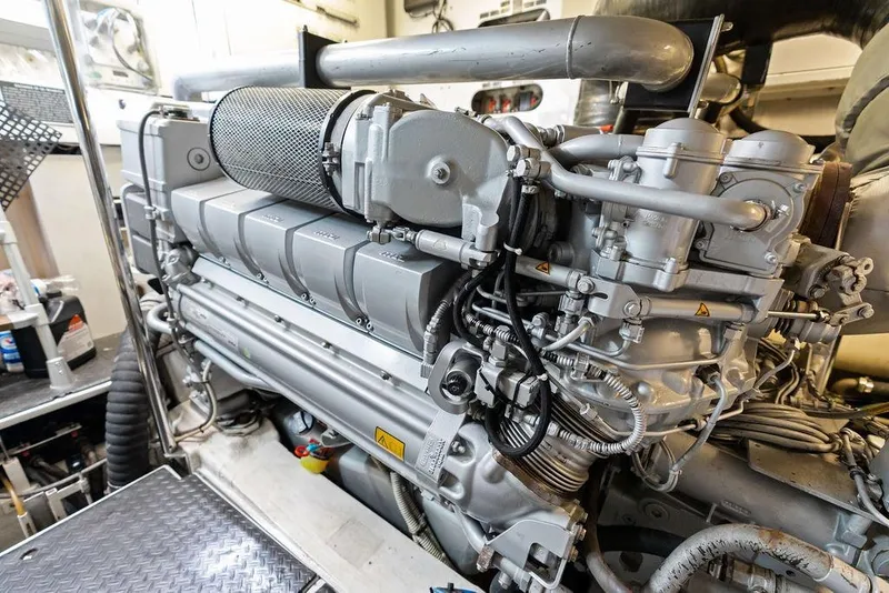Slide: The Image of Engine room of a 2013 Pershing 64 yacht, showcasing detailed machinery components. - 51