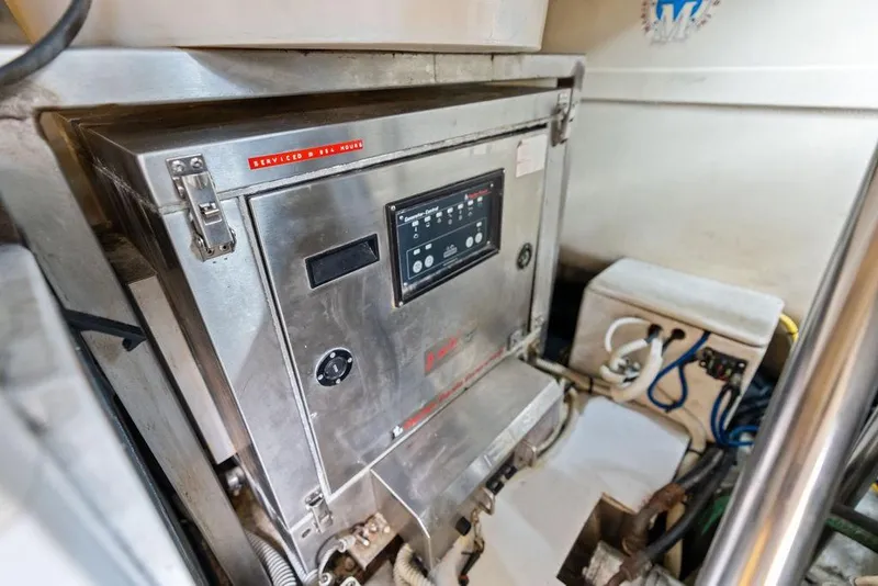 Slide: The Image of Engine room of a 2013 Pershing 64 yacht, featuring control panel and equipment. - 53