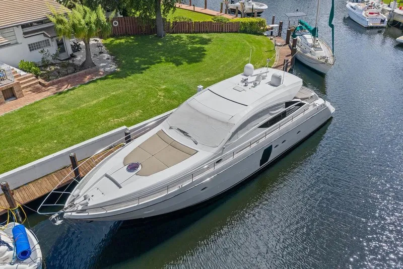 Slide: The Image of Luxurious 2013 Pershing 64 yacht docked by a waterfront property. - 6