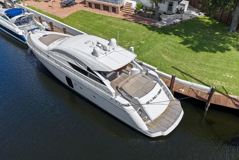 Slide: The Image of Luxury 2013 Pershing 64 yacht docked by a lush green lawn. - 7