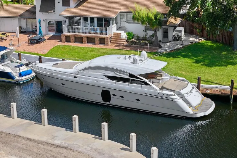 Slide: The Image of 2013 Pershing 64 yacht docked near a waterfront home, showcasing sleek design and luxury. - 9