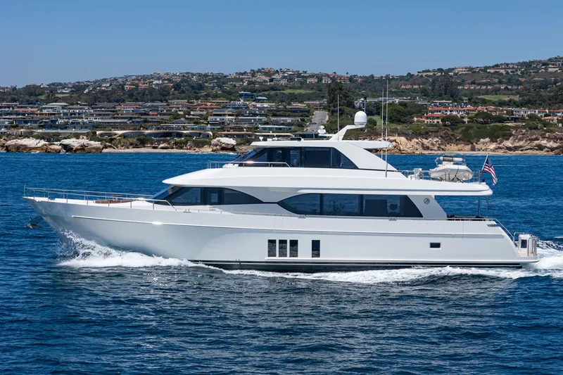 Slide: The Image of A luxurious motor yacht cruising on the sea, with a coastal landscape in the background. - 1