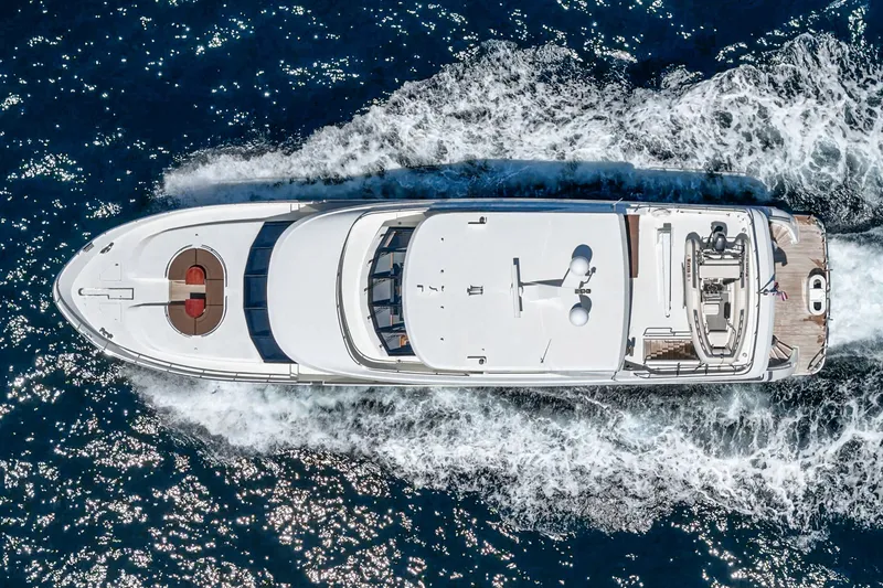 Slide: The Image of Aerial view of a luxury motor yacht cruising through blue water, with visible deck and waves. - 13