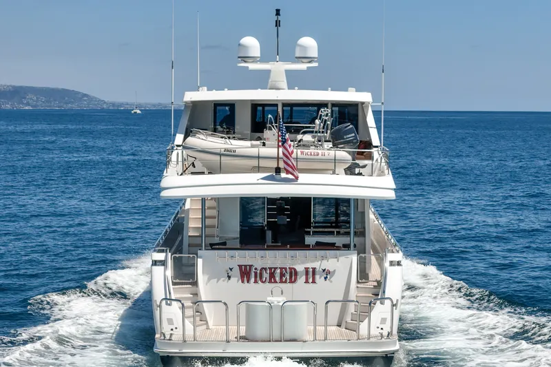 Slide: The Image of A luxurious motor yacht cruising on the sea, featuring a spacious deck and an American flag. - 17
