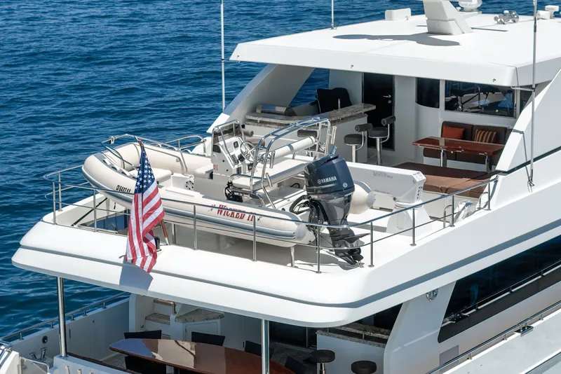 Slide: The Image of A luxury motor yacht with a tender on the upper deck, surrounded by blue water. - 18