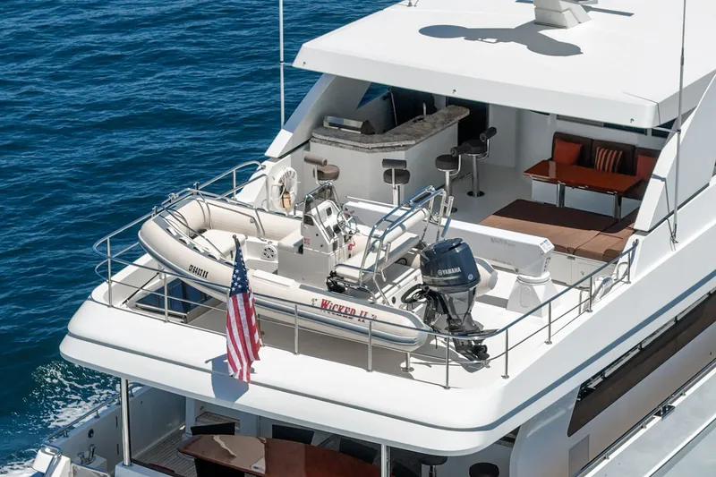 Slide: The Image of The 2015 Ocean Alexander 90 Skylounge Motoryacht features an elegant upper deck with a tender. - 19