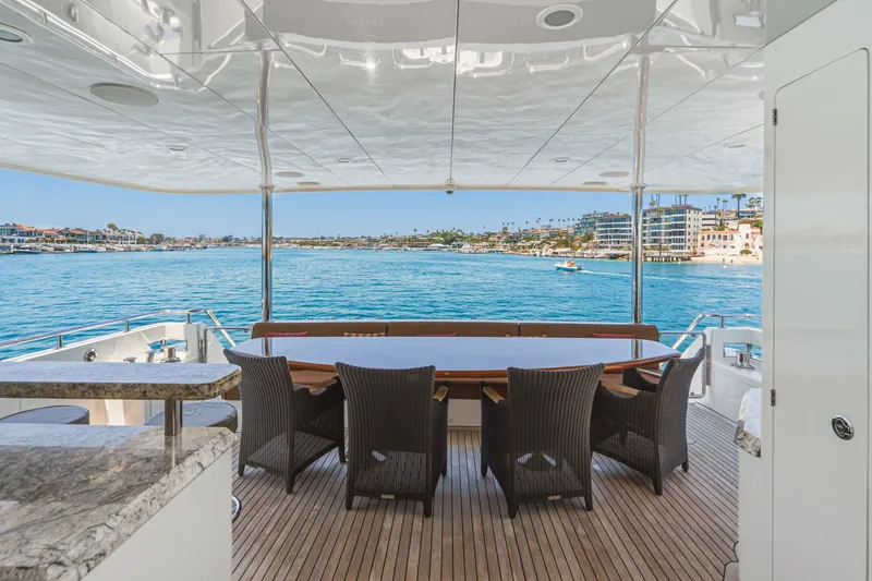 Slide: The Image of The 2015 Ocean Alexander 90 Skylounge Motoryacht features an elegant deck overlooking the water. - 26