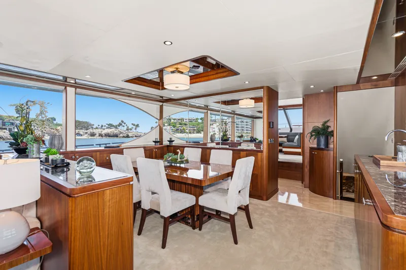 Slide: The Image of Interior of a luxury yacht with dining area, wooden furnishings, and large windows overlooking the water. - 37