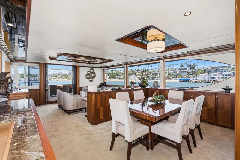 Slide: The Image of Luxurious dining area with wooden furniture and large windows offering a view of the harbor. - 38