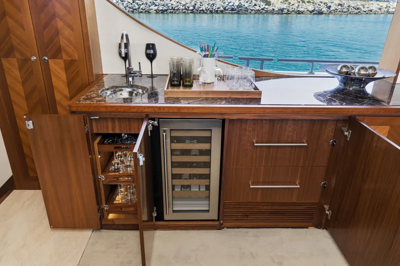 Slide: The Image of Luxurious yacht kitchen with wooden cabinets, wine cooler, and ocean view. - 42