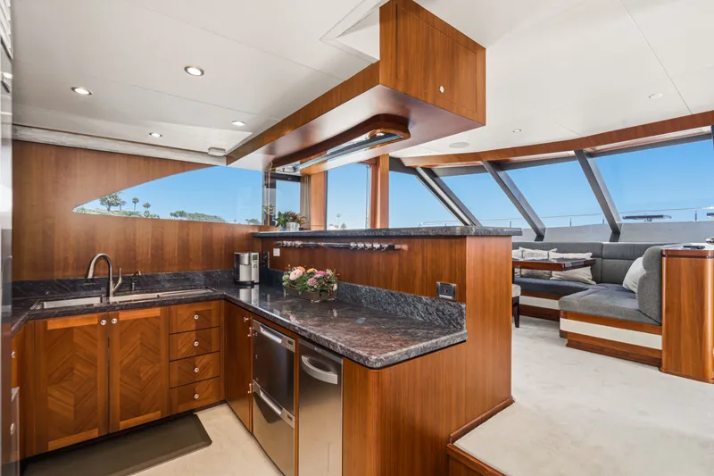 Slide: The Image of The luxurious galley of the 2015 Ocean Alexander 90 Skylounge Motoryacht with wood paneling and modern appliances. - 46