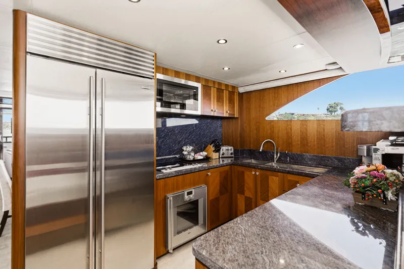 Slide: The Image of Kitchen of the 2015 Ocean Alexander 90 Skylounge Motoryacht with modern appliances and wood paneling. - 48