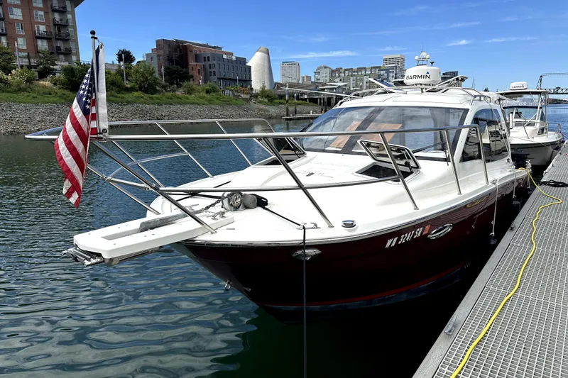 The Image of 2017 Cutwater C-24 Coupe docked, displaying American flag, urban waterfront backdrop. - 0