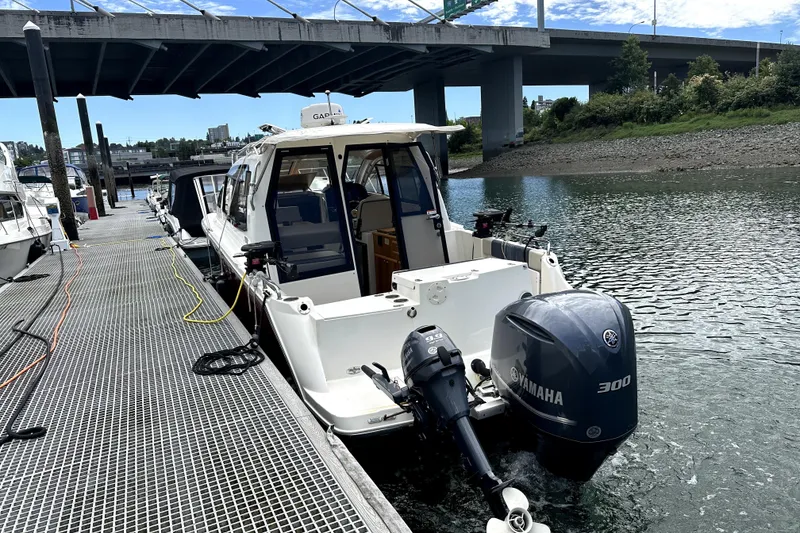 Slide: The Image of 2017 Cutwater C-24 Coupe docked, featuring Yamaha 300 engine under a bridge. - 1