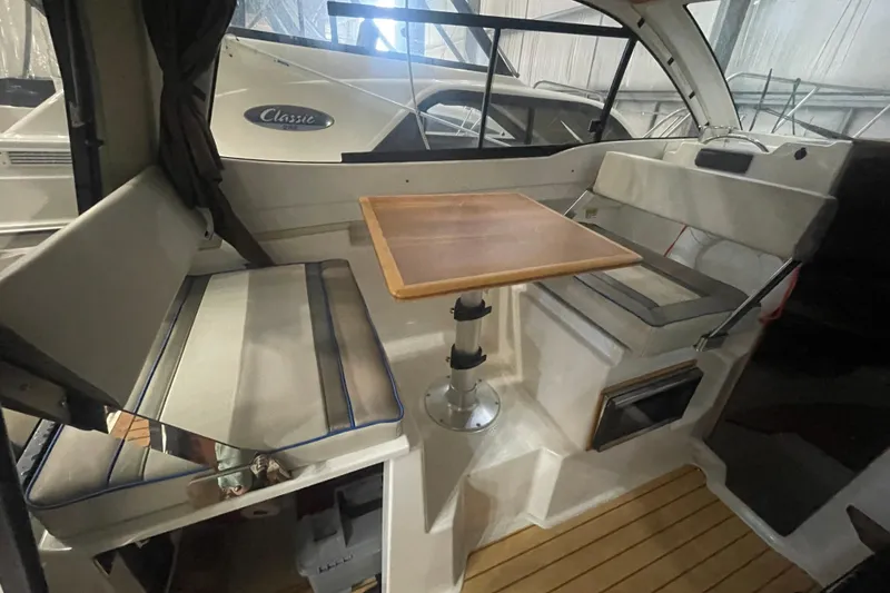 Slide: The Image of Interior of a 2017 Cutwater C-24 Coupe boat with seating and a wooden table. - 11