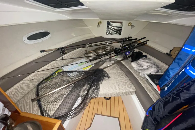Slide: The Image of 2017 Cutwater C-24 Coupe cabin with fishing gear and rods on bed. - 14