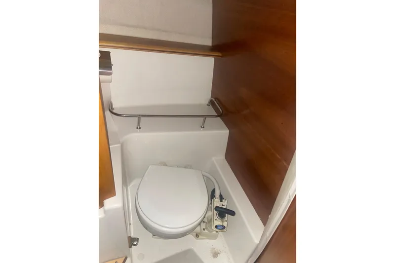 Slide: The Image of 2017 Cutwater C-24 Coupe boat bathroom with compact toilet and wooden paneling. - 15