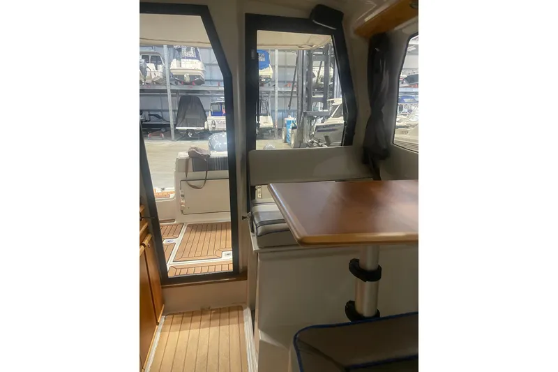 Slide: The Image of Interior view of 2017 Cutwater C-24 Coupe boat with wooden table and seating. - 16