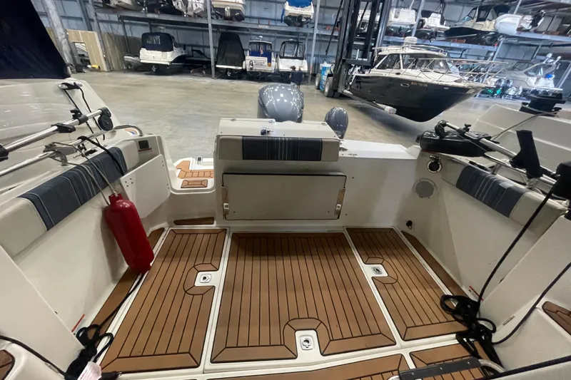 Slide: The Image of 2017 Cutwater C-24 Coupe interior with teak flooring in a boat storage facility. - 6