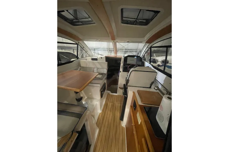Slide: The Image of Interior of 2017 Cutwater C-24 Coupe boat with wood accents and seating area. - 8