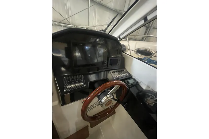 Slide: The Image of 2017 Cutwater C-24 Coupe helm with wooden steering wheel and modern controls. - 9