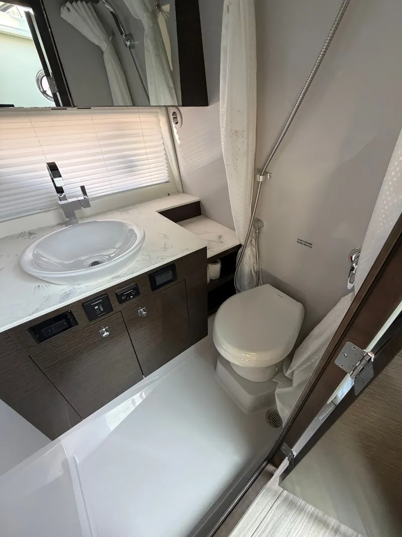 Slide: The Image of The image shows a modern yacht bathroom with a sink, toilet, and shower. - 10