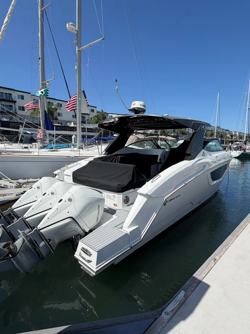 Slide: The Image of A luxurious 2021 Cruisers Yachts 38 GLS docked in a marina, surrounded by sailboats. - 3