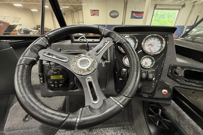 Slide: The Image of Steering wheel and dashboard of 2026 Tracker Targa V-19 WT boat, featuring gauges and controls. - 14