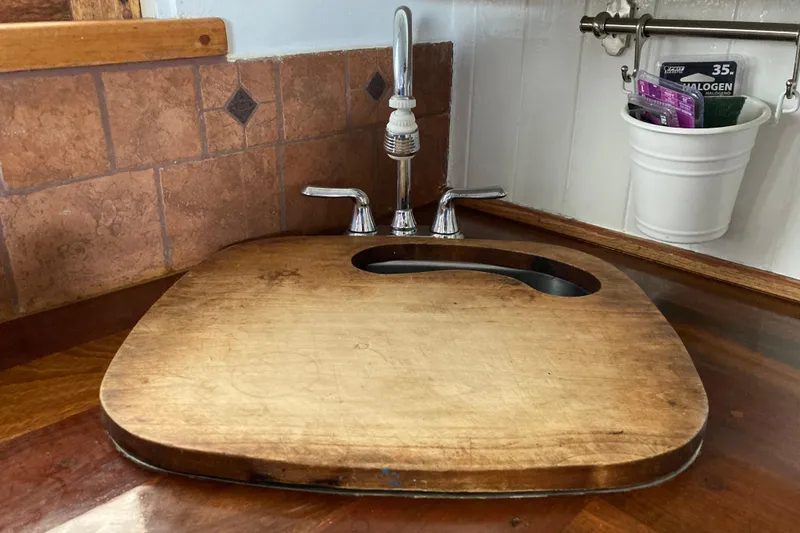 Slide: The Image of Wooden sink cover on Grenfell 42 Custom boat, 1942 model, with faucet and tiled backsplash. - 10