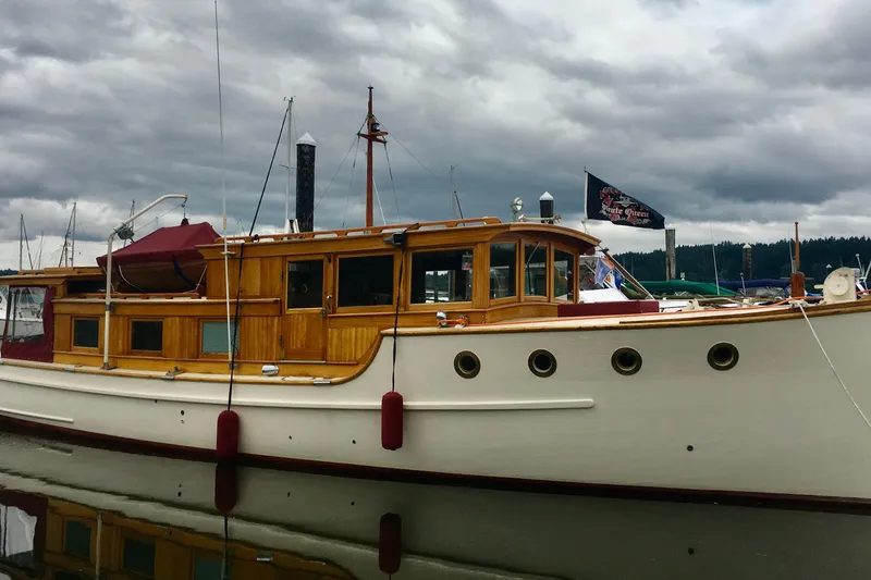 Slide: The Image of Vintage 1942 Grenfell 42 Custom boat with wooden cabin, docked under cloudy skies. - 13