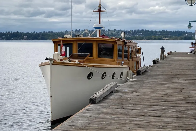 Slide: The Image of Vintage 1942 Grenfell 42 Custom boat docked by a wooden pier on a cloudy day. - 2
