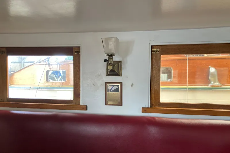 Slide: The Image of Interior of a 1942 Grenfell 42 Custom boat with wooden-framed windows and a wall lamp. - 4