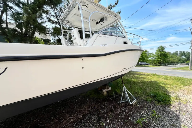 Slide: The Image of Boston Whaler 285 Conquest 2006 boat on land, surrounded by trees and a clear sky. - 10